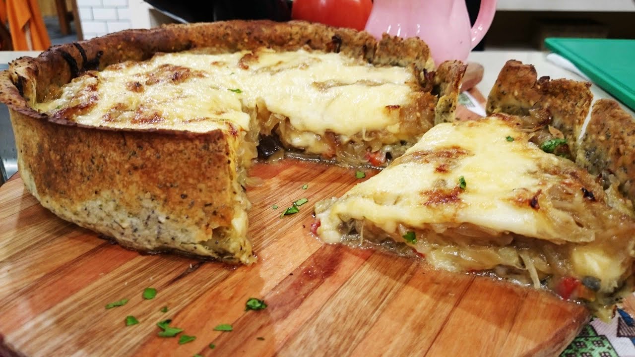 Tarta de berenjenas en masa de semillas con cubierta de cebolla y queso